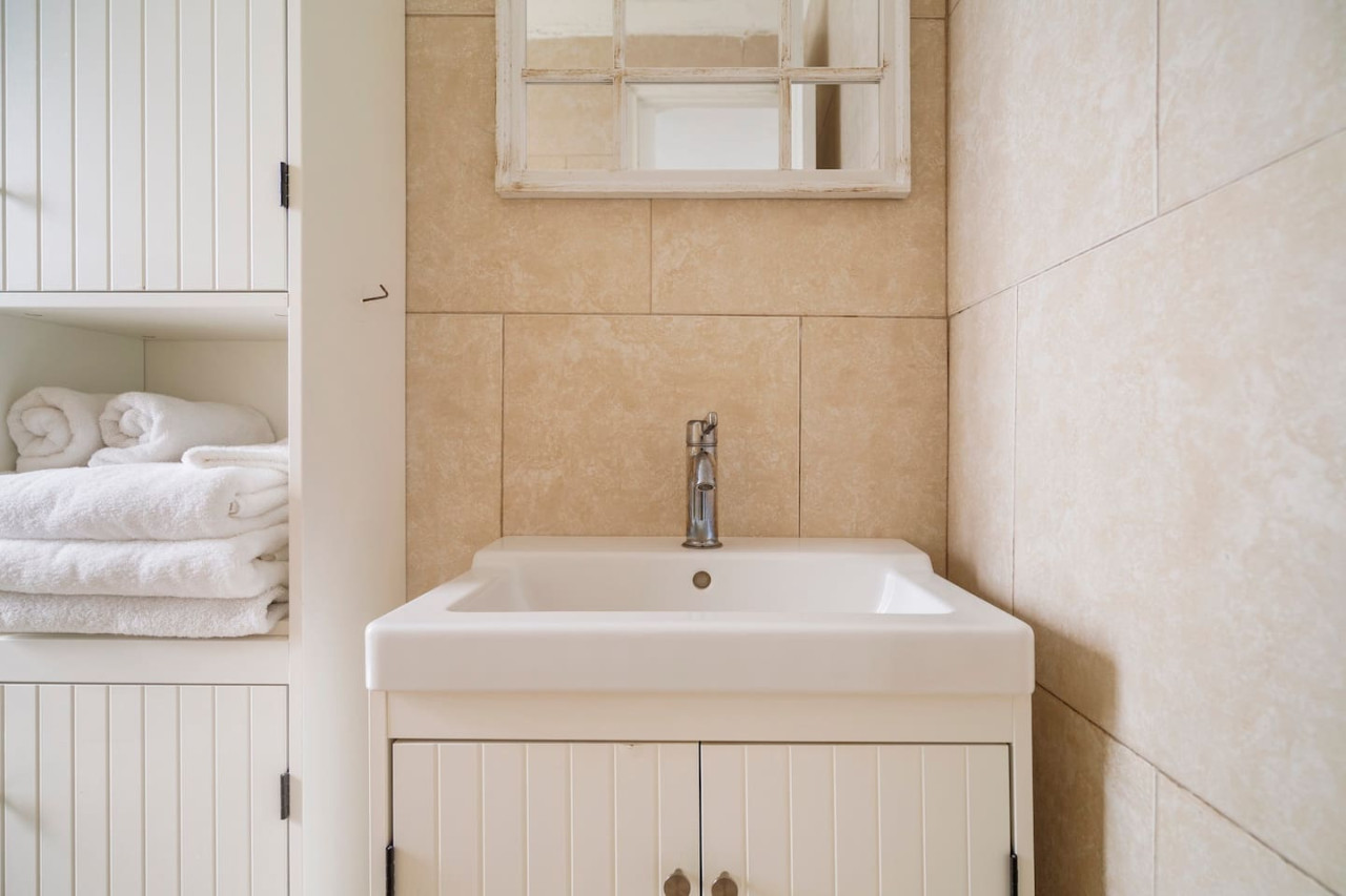 White bathroom sink with a mirror above it — Sunset Haven | Ocean Breeze | Old San Juan, Old San Juan