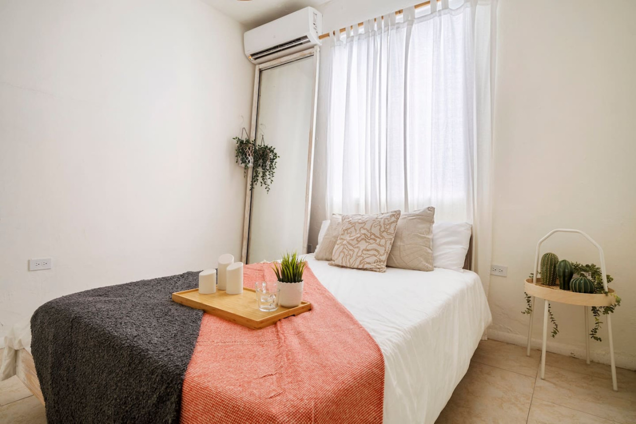 Bedroom with a bed and a mirror — Sunset Haven | Ocean Breeze | Old San Juan, Old San Juan