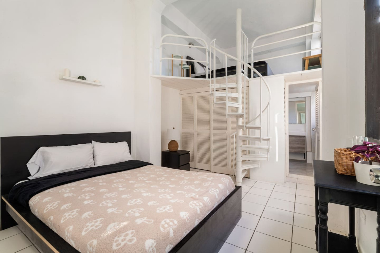 Bedroom with a black bed and a white and black comforter — Spanish Penthouse Historic Mansion Private Patio, Old San Juan