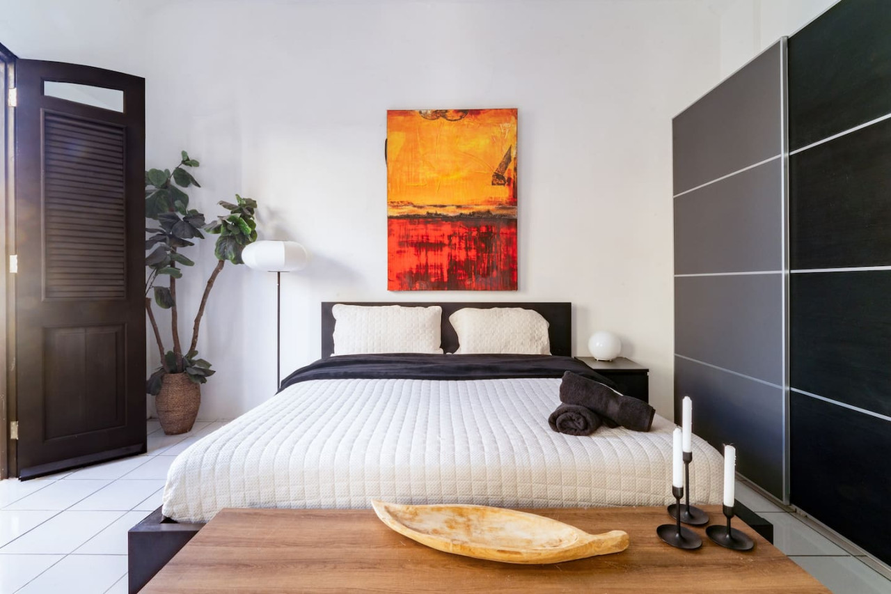 Bedroom with a large bed and a painting on the wall — Spanish Penthouse Historic Mansion Private Patio, Old San Juan
