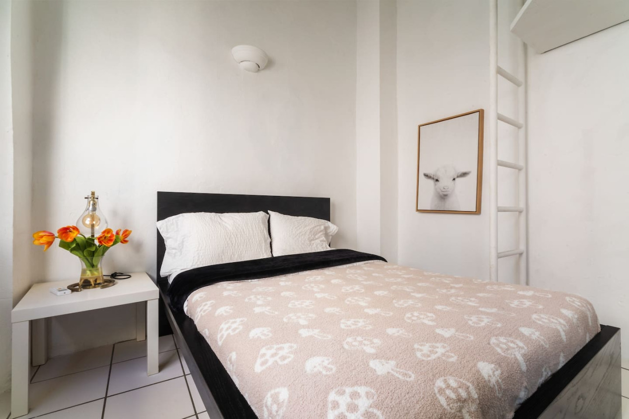 Bedroom with a black bedspread and white pillows — Spanish Penthouse Historic Mansion Private Patio, Old San Juan
