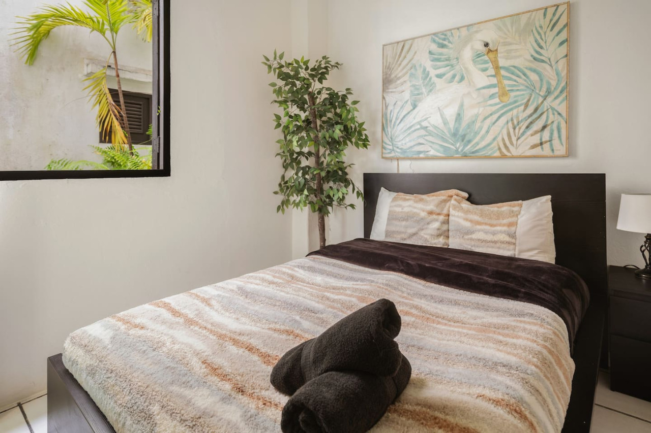 Bedroom with a bed and a potted plant — Spanish Duplex | Private Patio | Walk to Ocean, Old San Juan