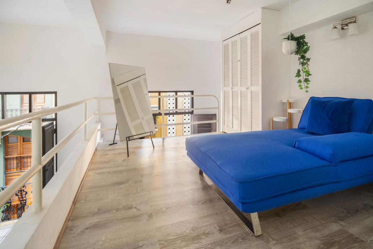 Blue couch in a bedroom — Spanish Duplex | Private Patio | Walk to Ocean, Old San Juan