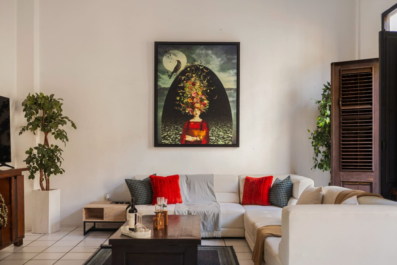 Living room with a couch and a painting on the wall — Spanish Duplex | Private Patio | Walk to Ocean, Old San Juan