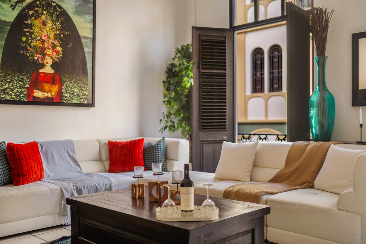 Living room with a couch and a bottle of wine on a table — Spanish Duplex | Private Patio | Walk to Ocean, Old San Juan