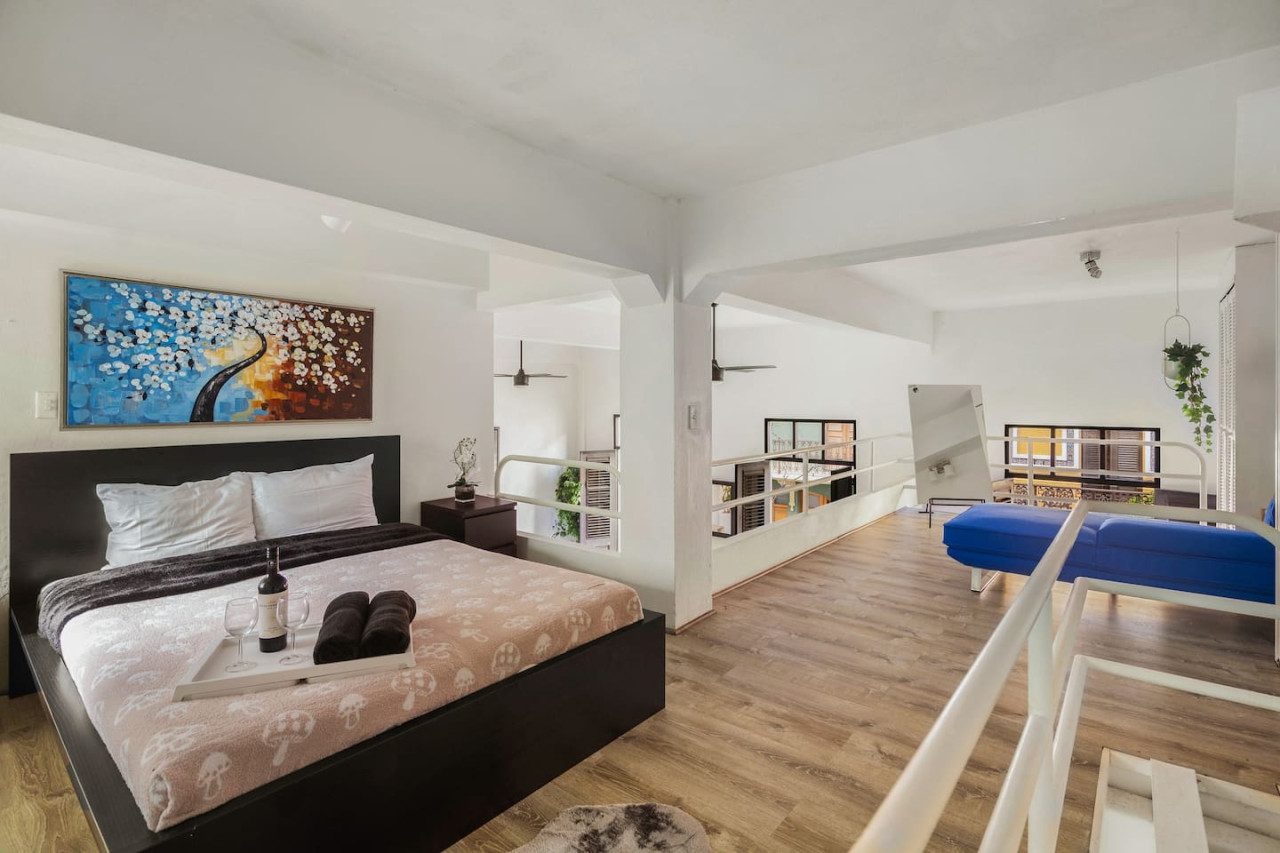 Bedroom with a bed and a painting on the wall — Spanish Duplex | Private Patio | Walk to Ocean, Old San Juan