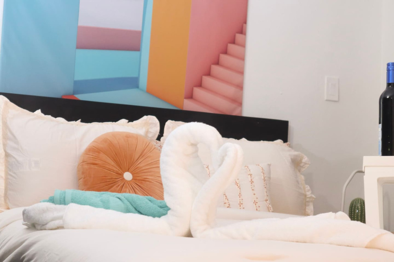 Bedroom with a white bedspread and a colorful pillow — Puerto Escape | Old San Juan, Old San Juan