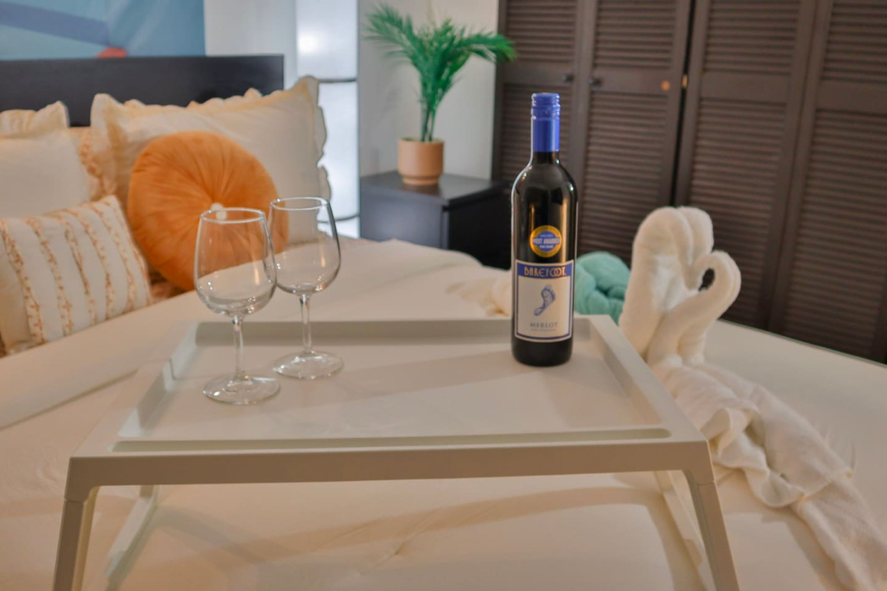 Bedroom with a bed and two wine glasses on a tray — Puerto Escape | Old San Juan, Old San Juan