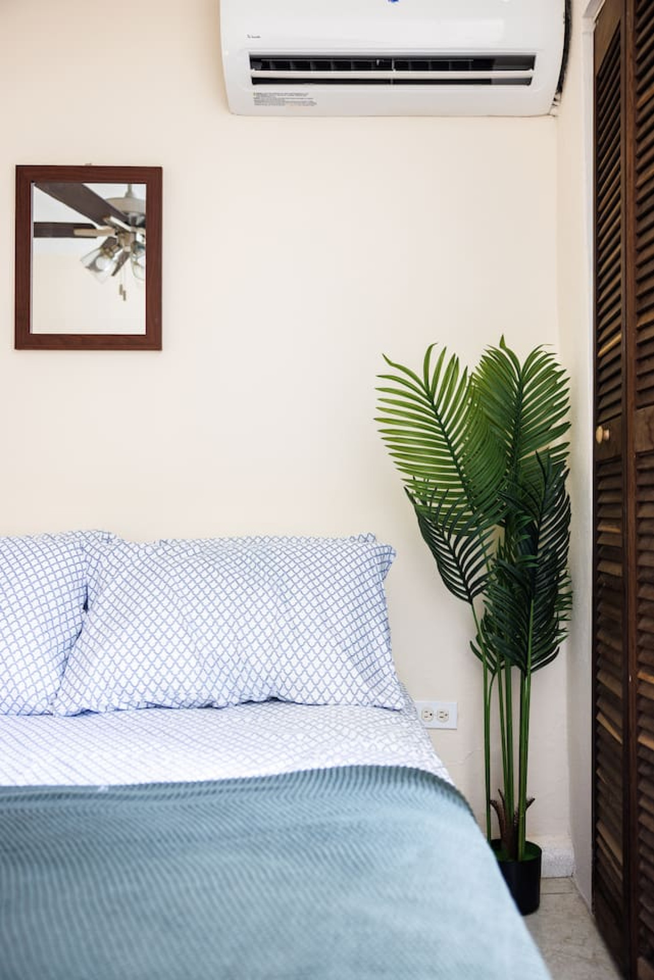 Bedroom with a blue bedspread and a potted plant on the side — Ocean Sol Historic Old San Juan, Old San Juan