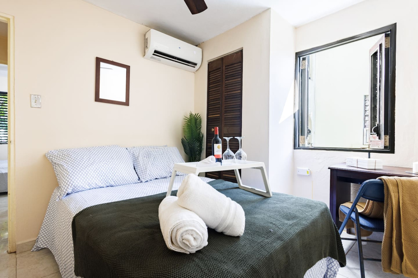 Bedroom with a bed, a table with two wine glasses, and a potted plant — Ocean Sol Historic Old San Juan, Old San Juan
