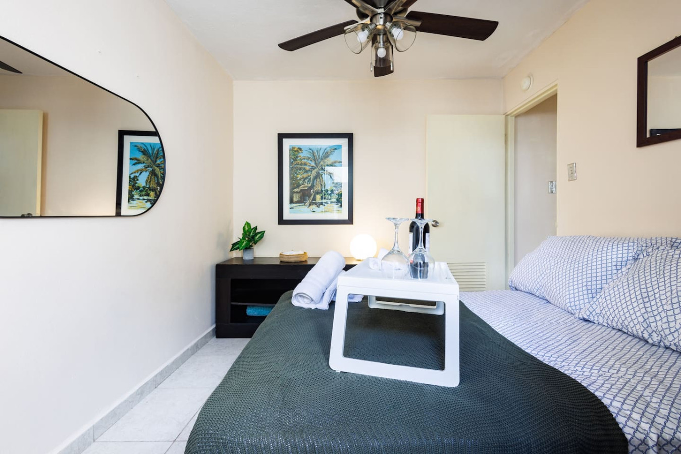 Bedroom with a bed, a table, a lamp, a bottle of wine, and a picture on the — Ocean Sol Historic Old San Juan, Old San Juan