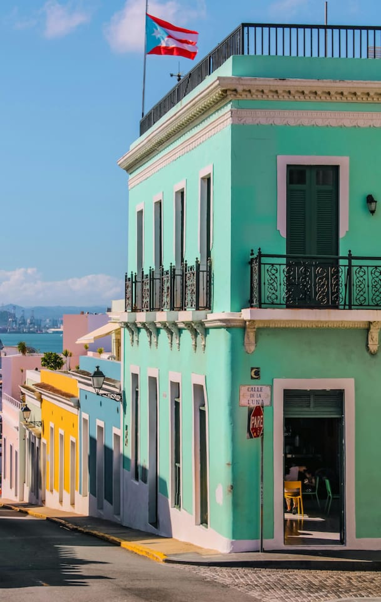 Blue and yellow building with a balcony — Ocean Sol Historic Old San Juan