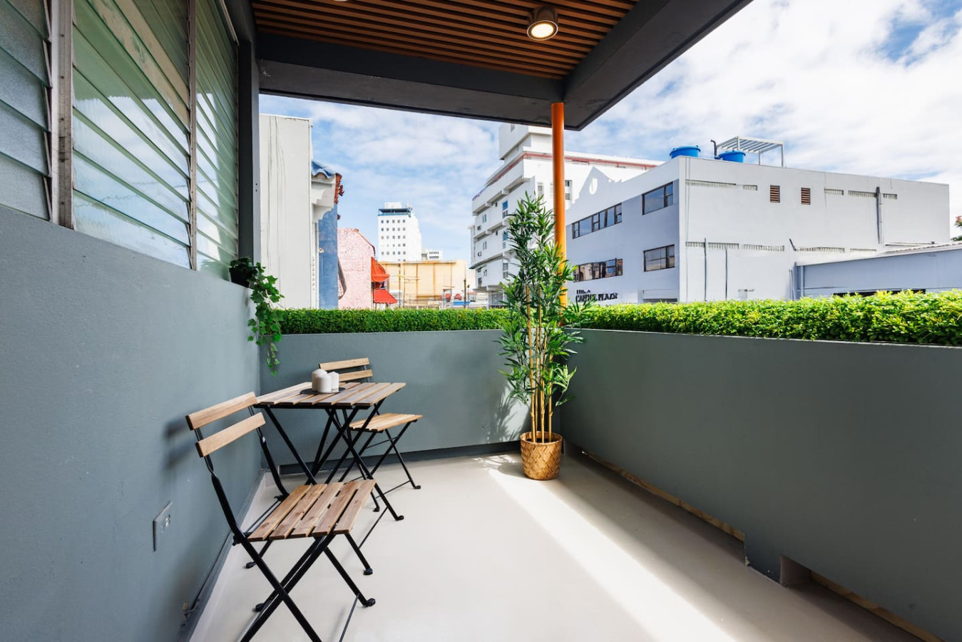 Balcony with a table and chairs overlooking the city — Spain Lagoon | San Juan | Private Patio, Santurce