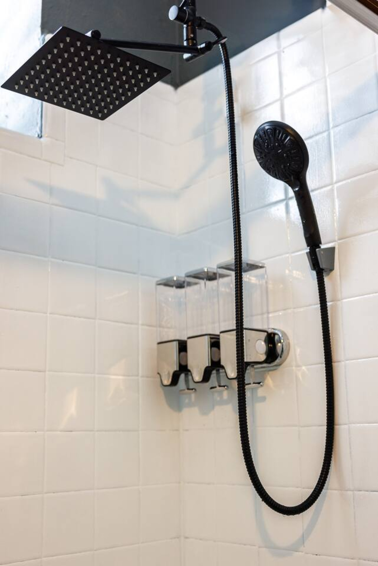 Bathroom shower with a rain head and soap dispensers — Spain Lagoon | San Juan | Private Patio, Santurce