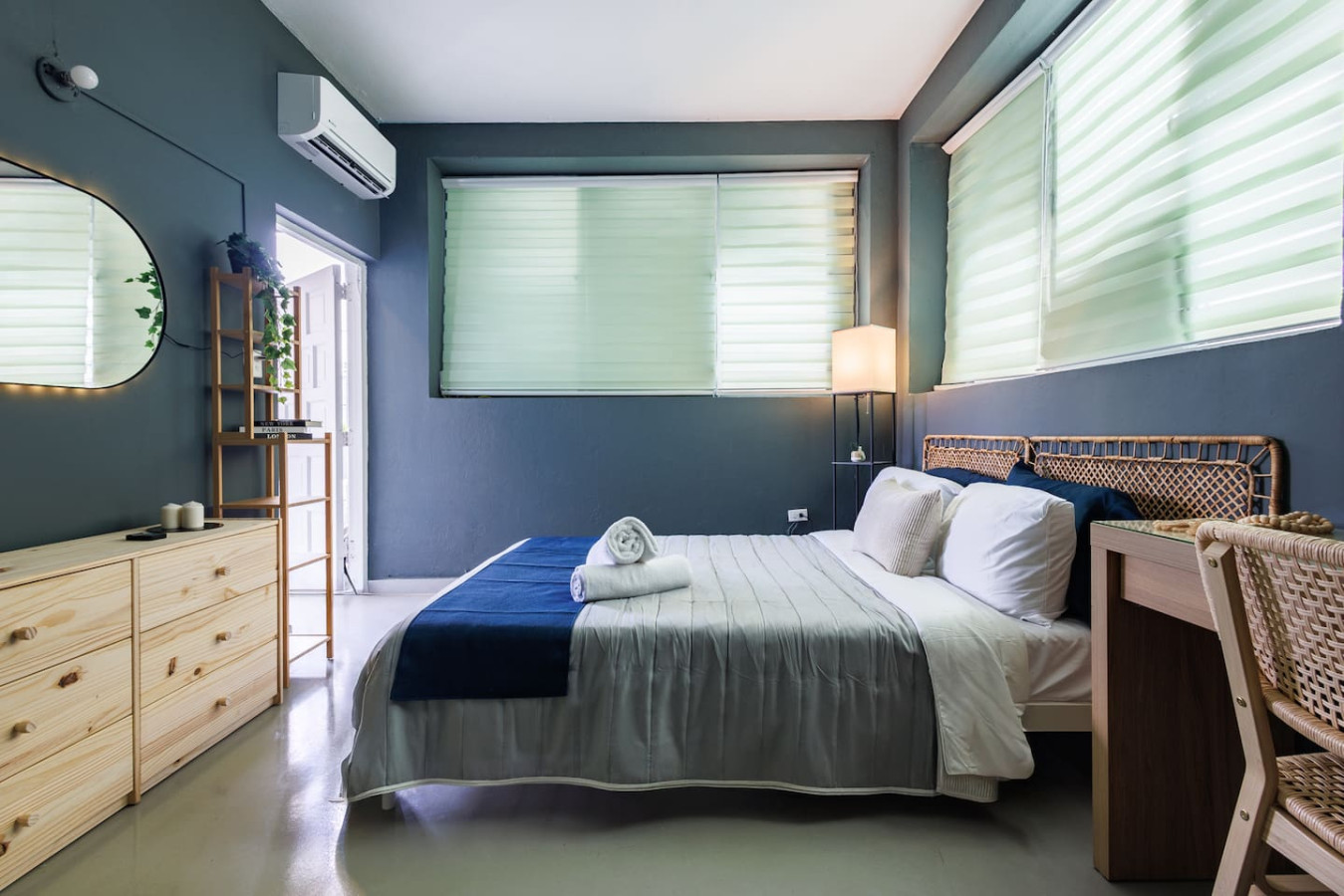 Bedroom with a blue bedspread and white sheets — Spain Lagoon | San Juan | Private Patio, Santurce