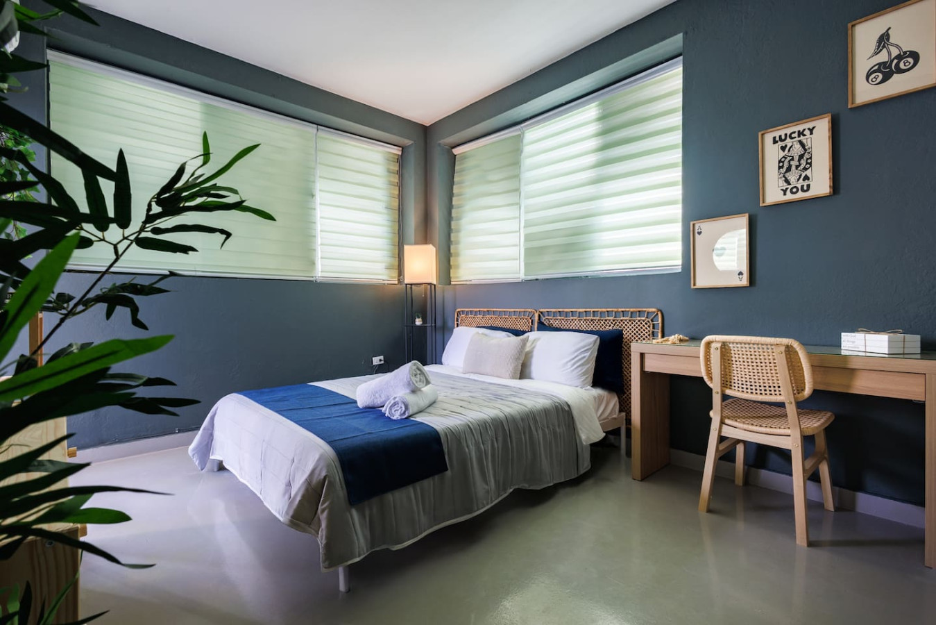 Bedroom with a blue bedspread and white pillows — Spain Lagoon | San Juan | Private Patio, Santurce