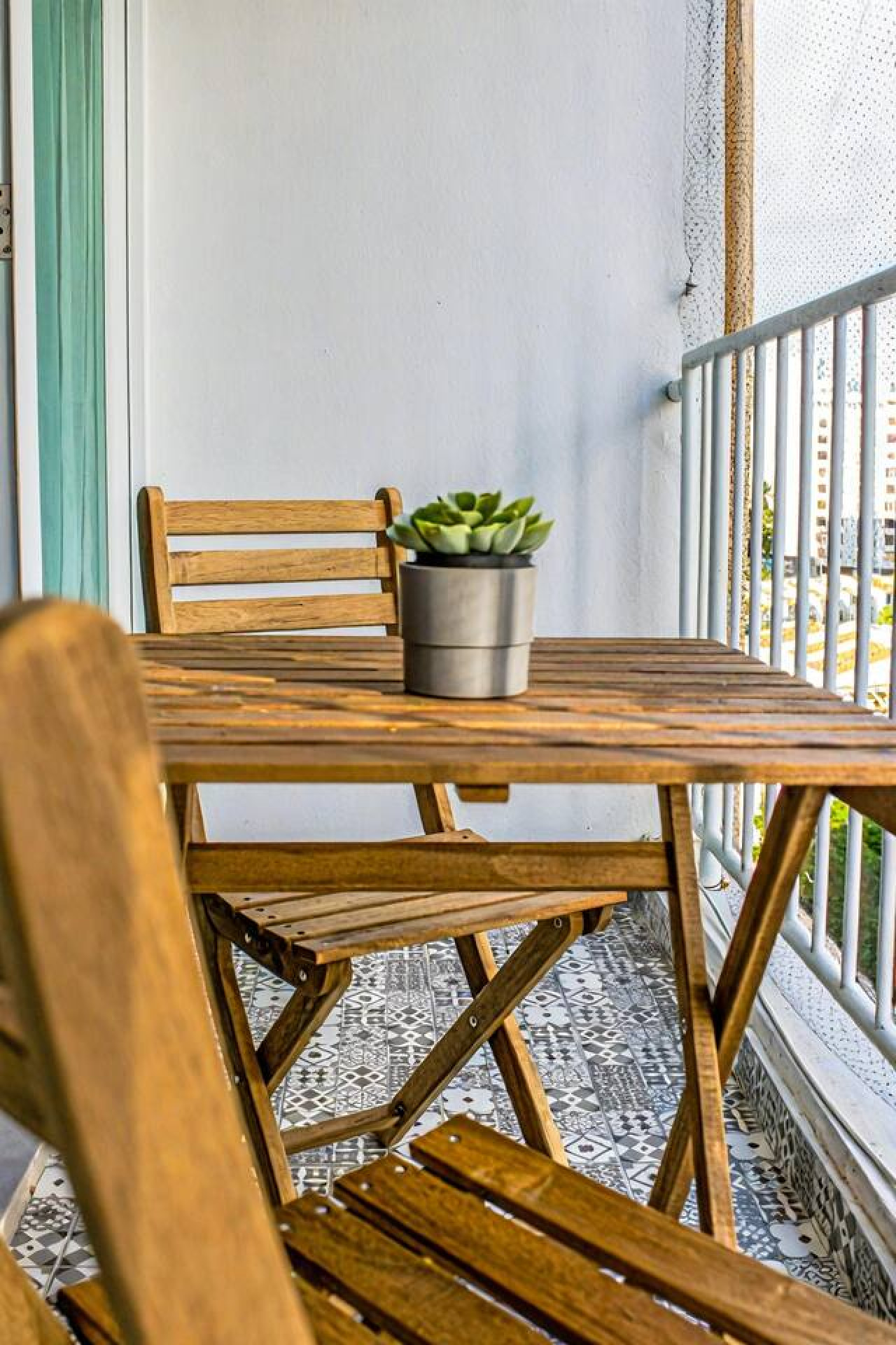 Wooden table with a potted plant on a balcony — OceanSide - Pool Balcony, Isla Verde