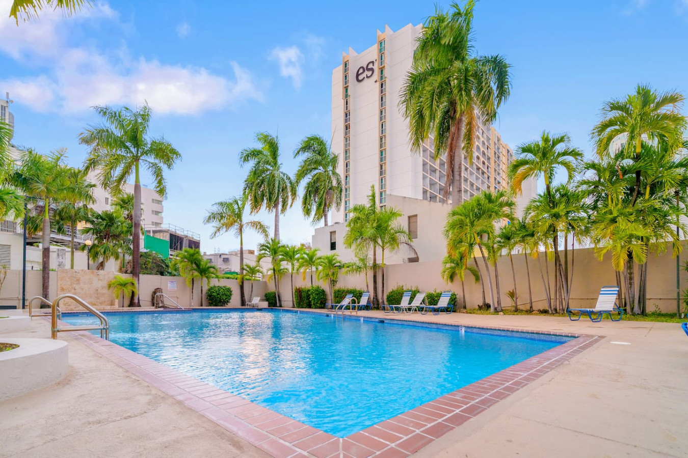 Large white building with palm trees in front of it — OceanSide - Pool Balcony, Isla Verde
