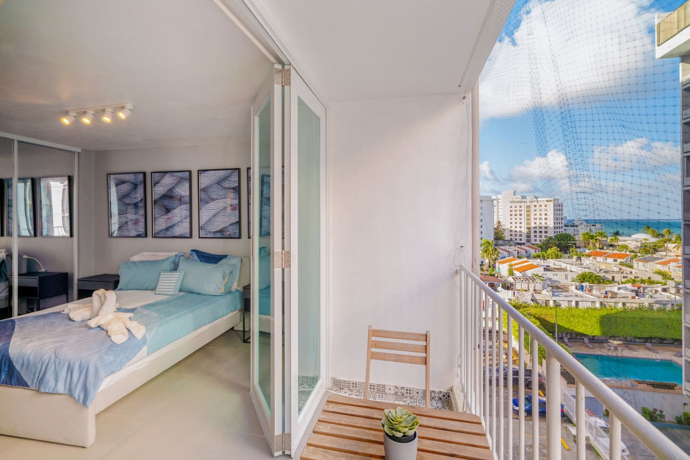 Bedroom with a bed, a chair, and a potted plant — OceanSide - Pool Balcony, Isla Verde