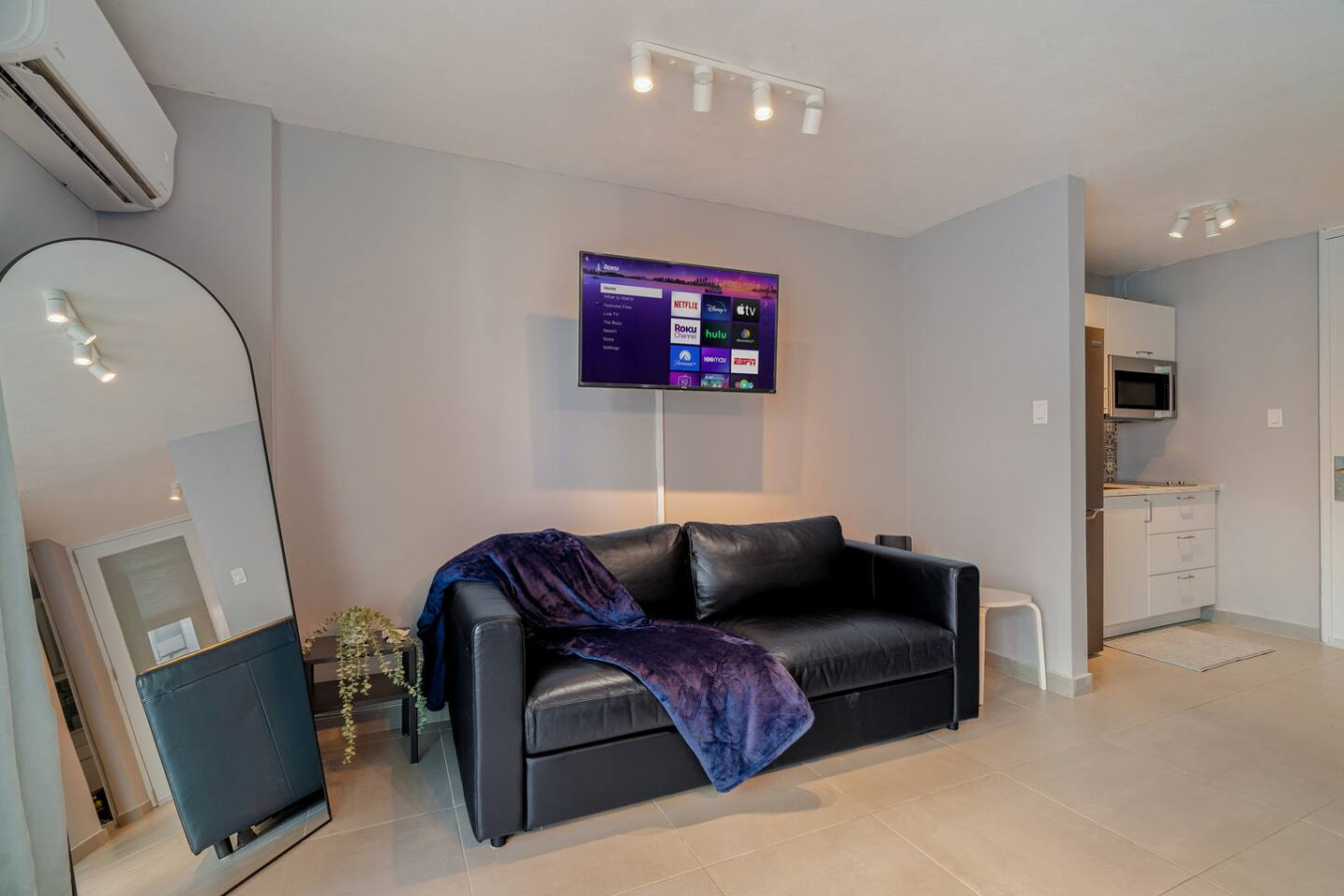 Black leather couch with a blue blanket on it — OceanSide - Pool Balcony, Isla Verde