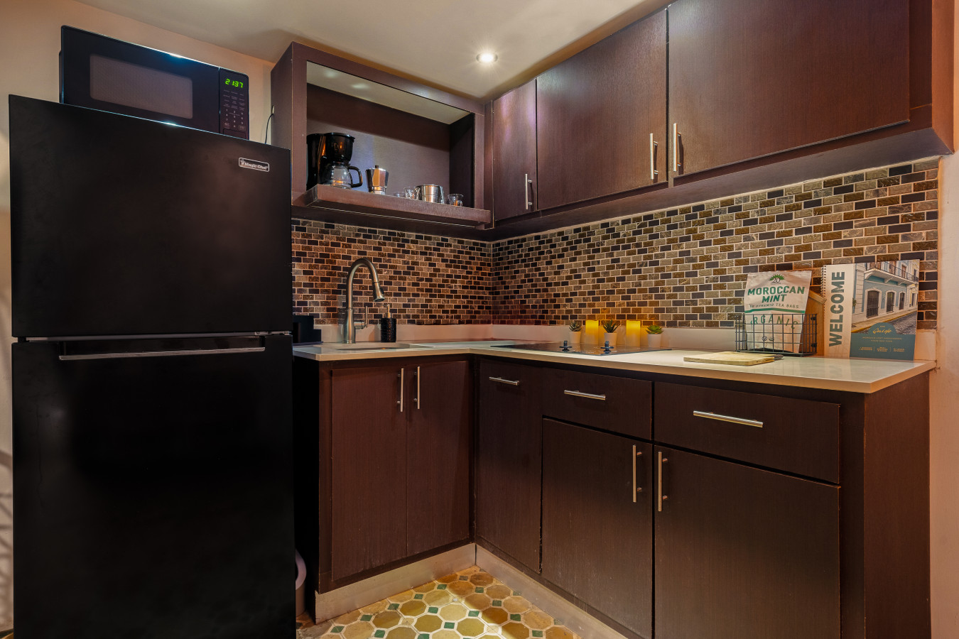 Kitchen with a black refrigerator, a sink, and a brown cabinet — Morocco Loft Sanjuanero | Viejo San Juan, Old San Juan