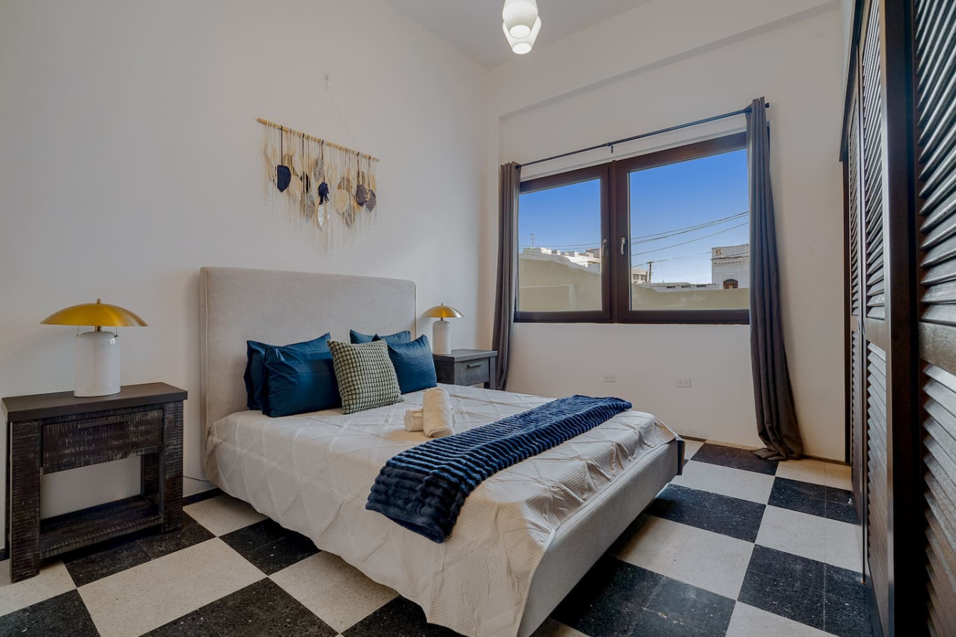 Bedroom with a bed, a lamp, and a window with a view of the city — Royal Palm Old San Juan, Old San Juan