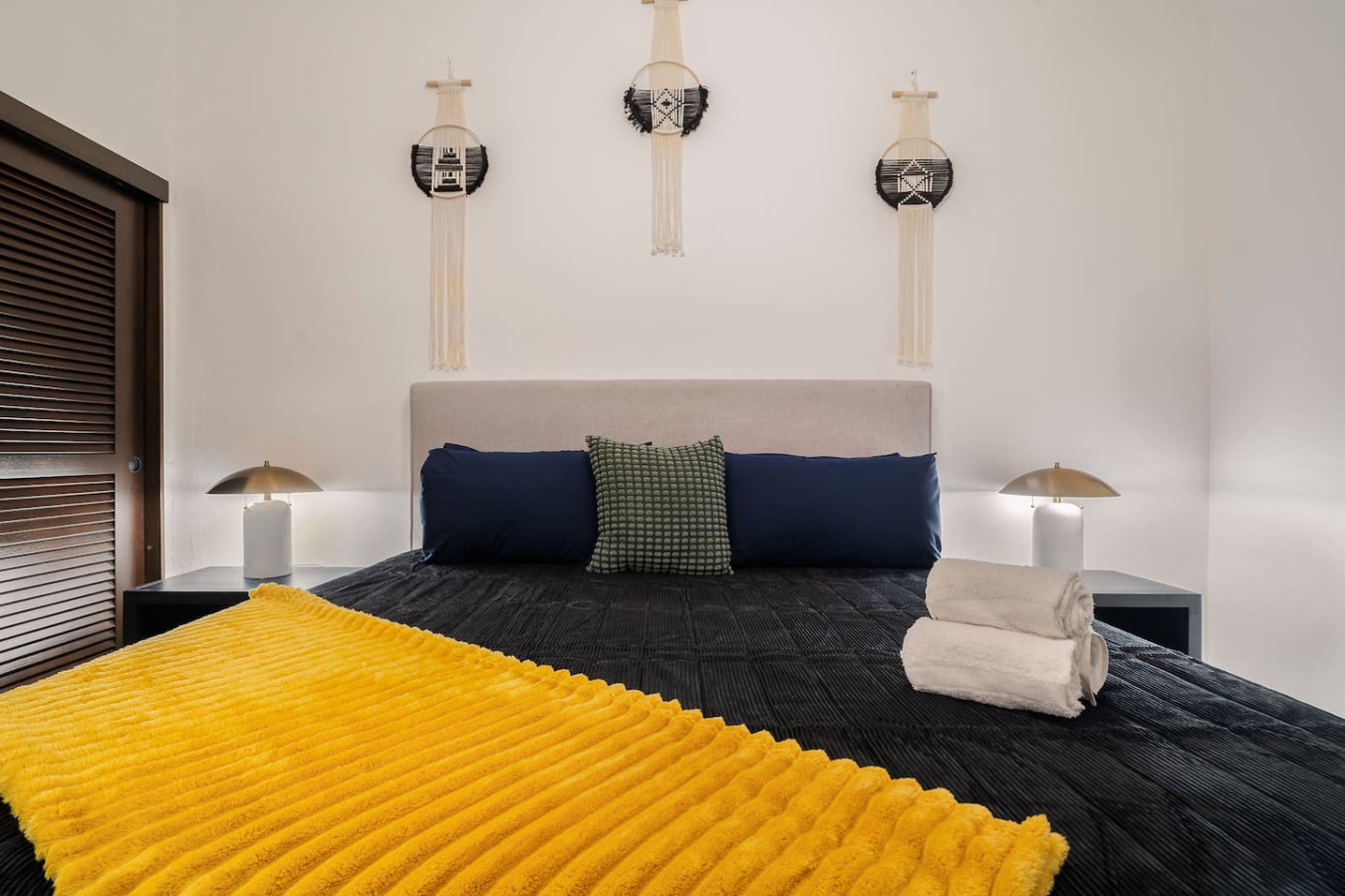 Bedroom with a yellow blanket on the bed and a black comforter — Soho House  The Grand Patio, Old San Juan