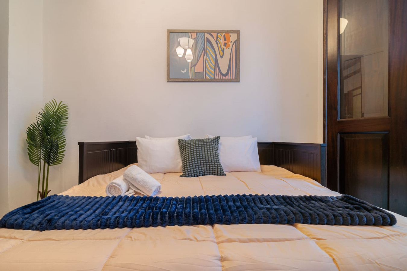 Bedroom with a blue blanket on the bed and a painting on the wall — Soho House  The Grand Patio, Old San Juan