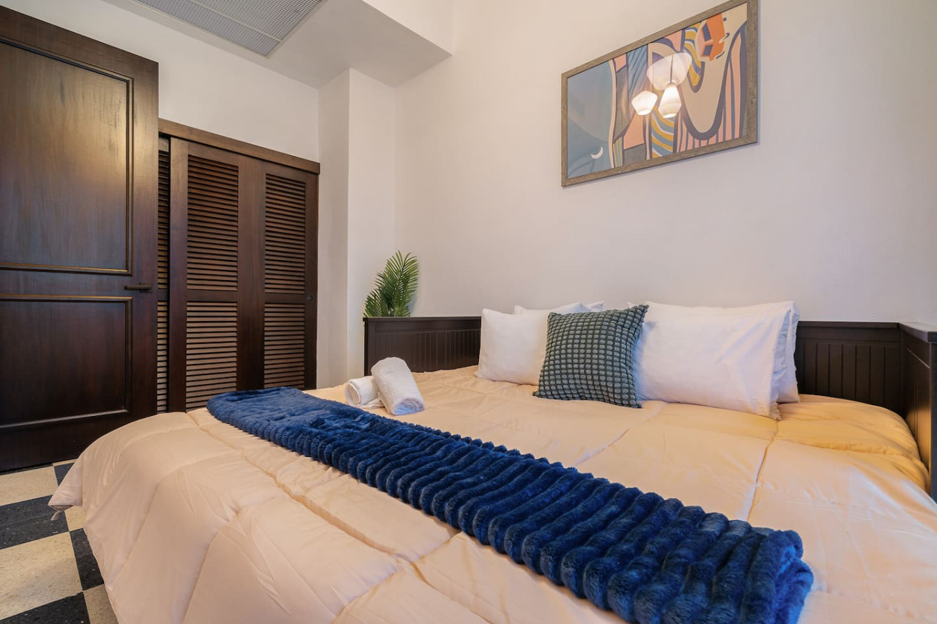 Bedroom with a bed, a potted plant, and a blue blanket on the bed — Soho House  The Grand Patio, Old San Juan