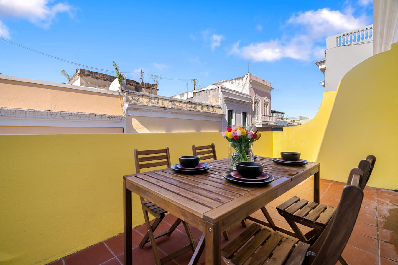Table with chairs and a vase of flowers on it — Soho Garden Grand patio, Old San Juan
