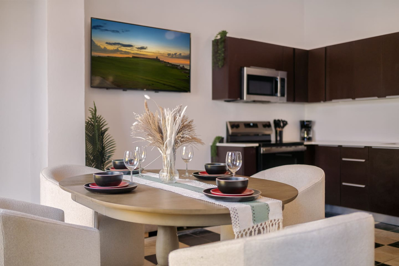 Dining table with a TV on the wall above it — Soho Garden Grand patio, Old San Juan