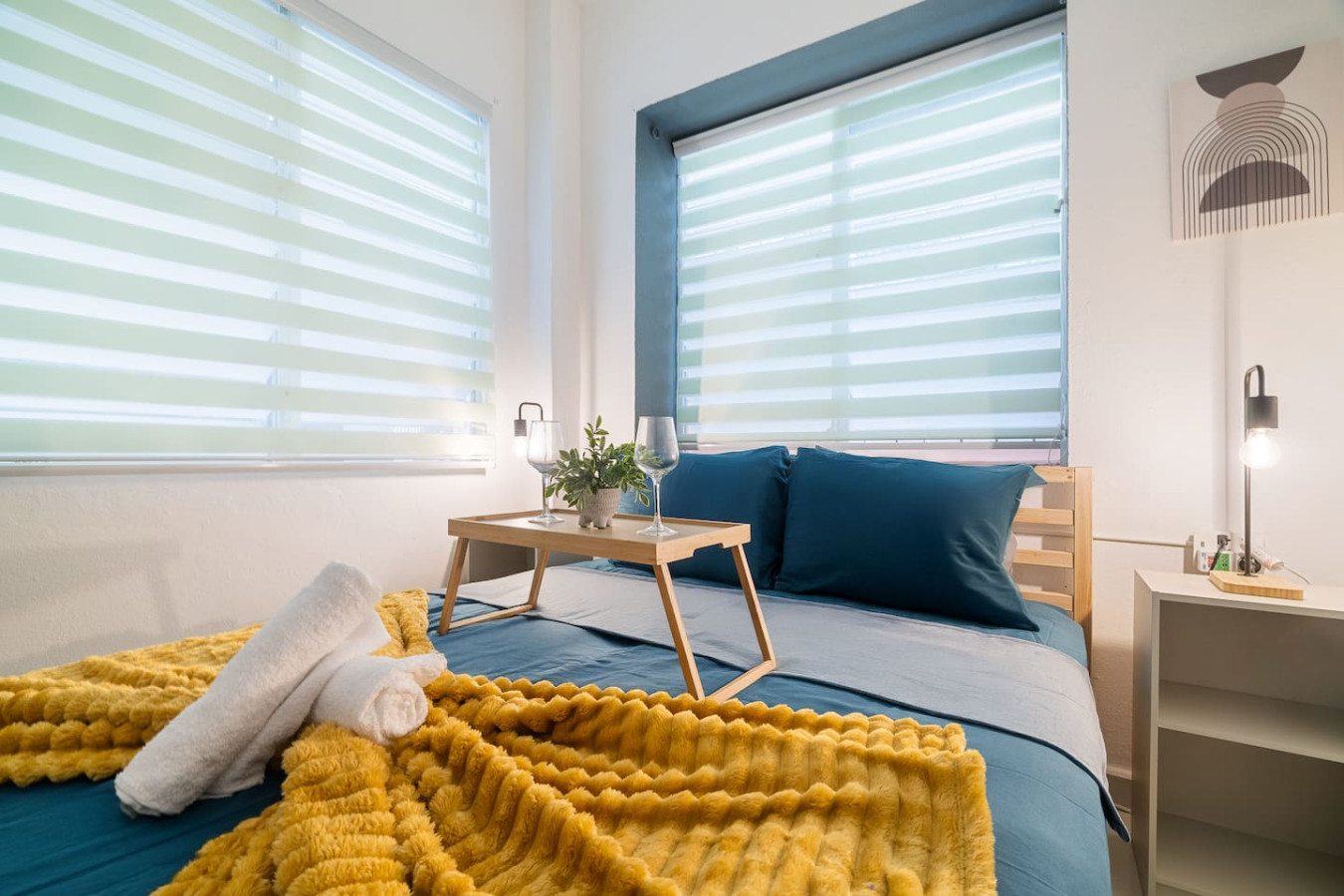 Bedroom with a yellow blanket on the bed and a table with a plant on it — Puerto House - Private Patio, Santurce