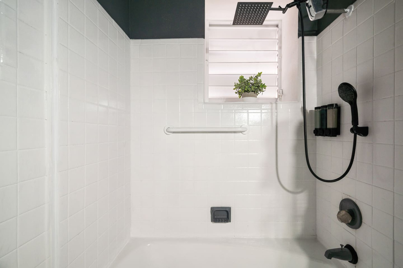 White bathroom with a shower and a potted plant on the window sill — Puerto House - Private Patio, Santurce