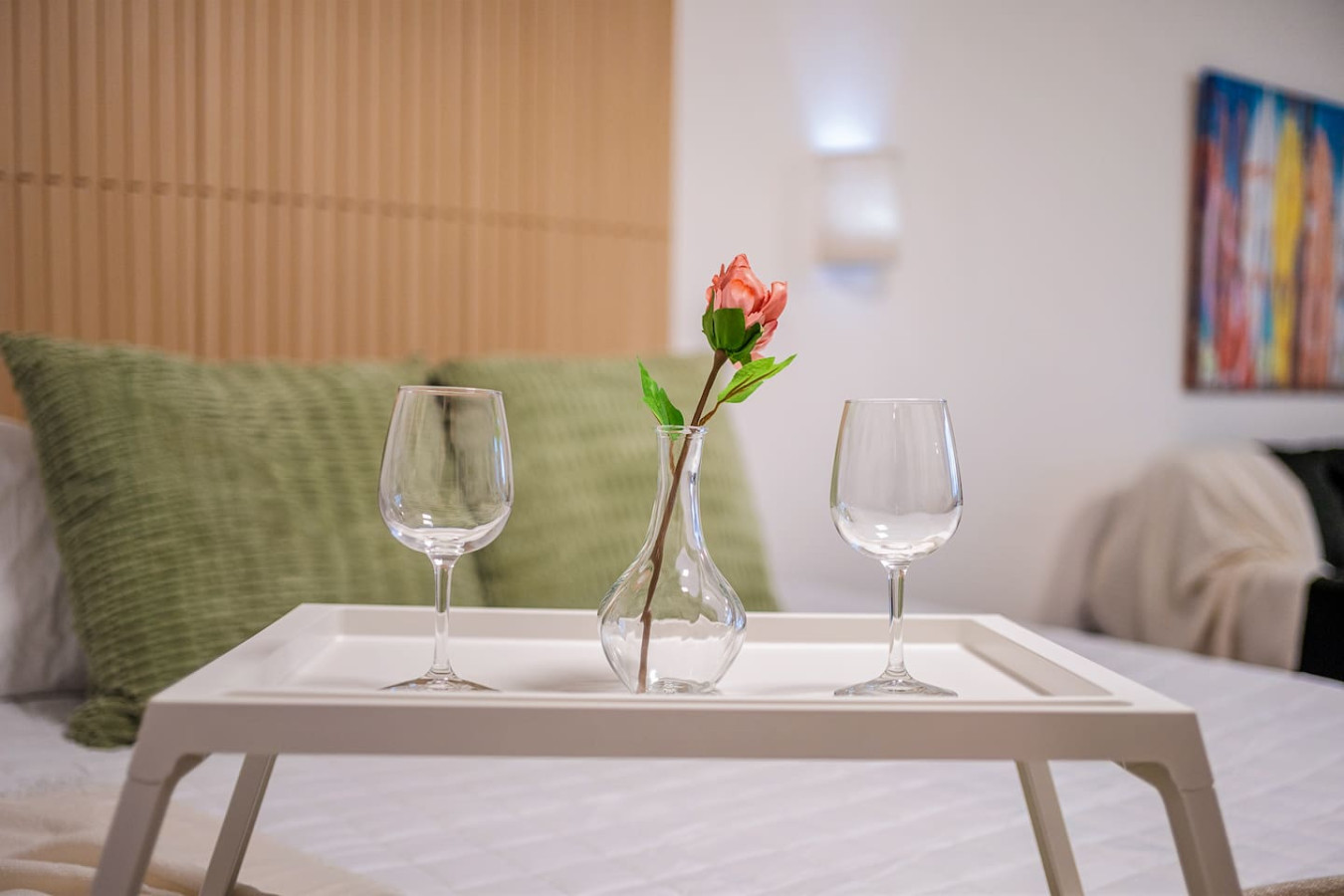 Bedroom with a bed, a table with two wine glasses and a vase with a flower on it — Condado Penthouse, Condado