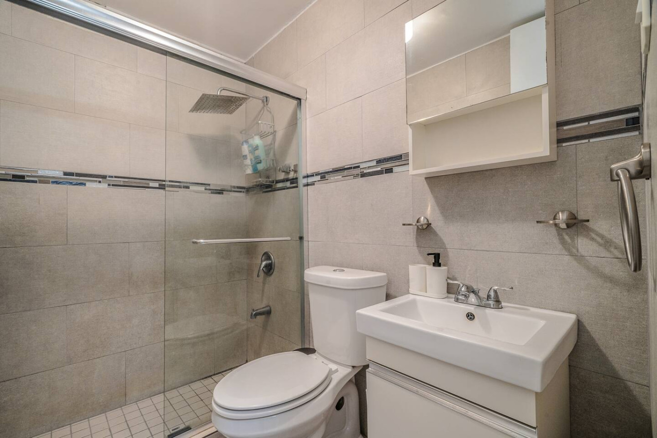 White toilet in a bathroom with a glass shower door — Condado Penthouse