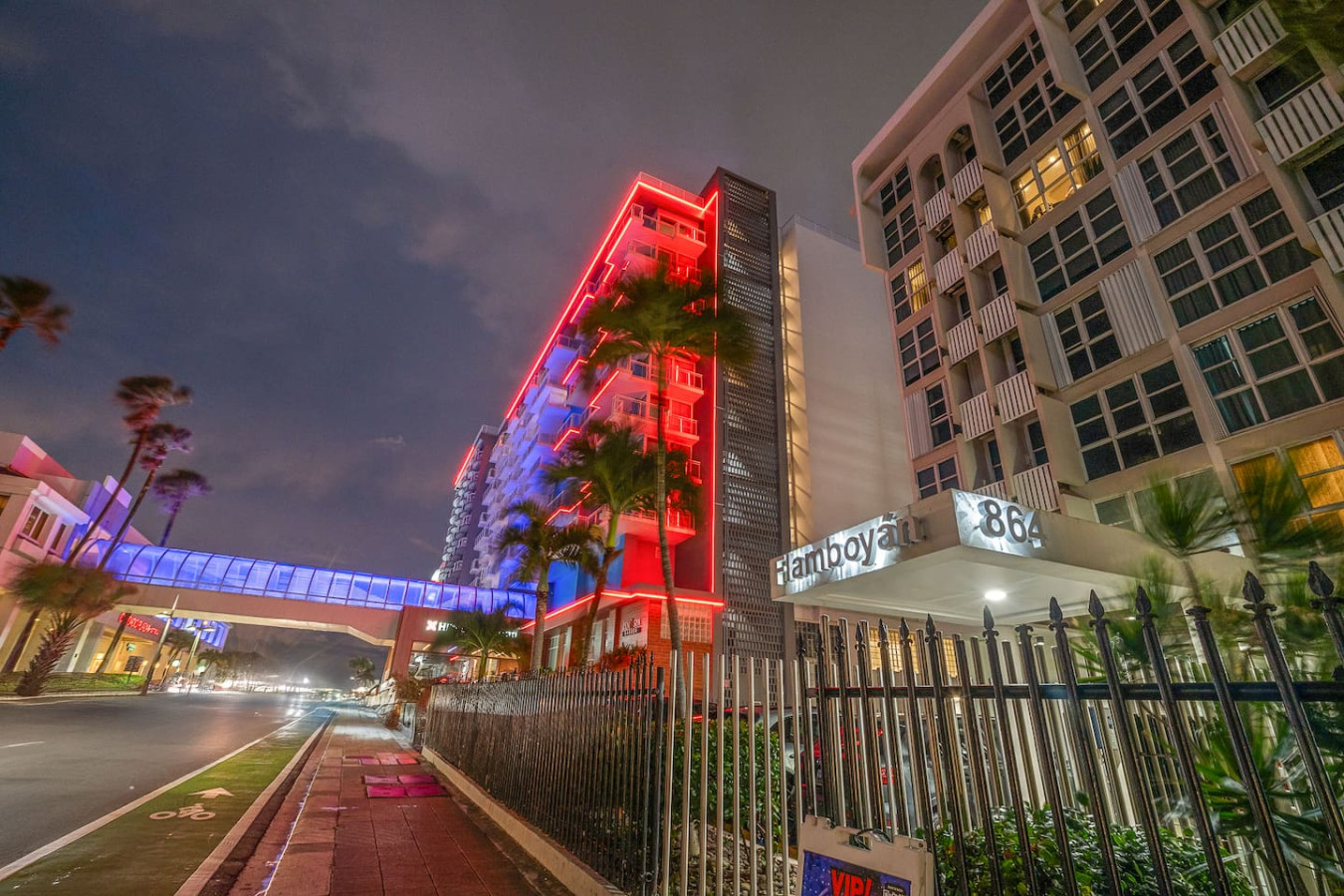 Palm-lined avenue outside the building at night — Condado Penthouse