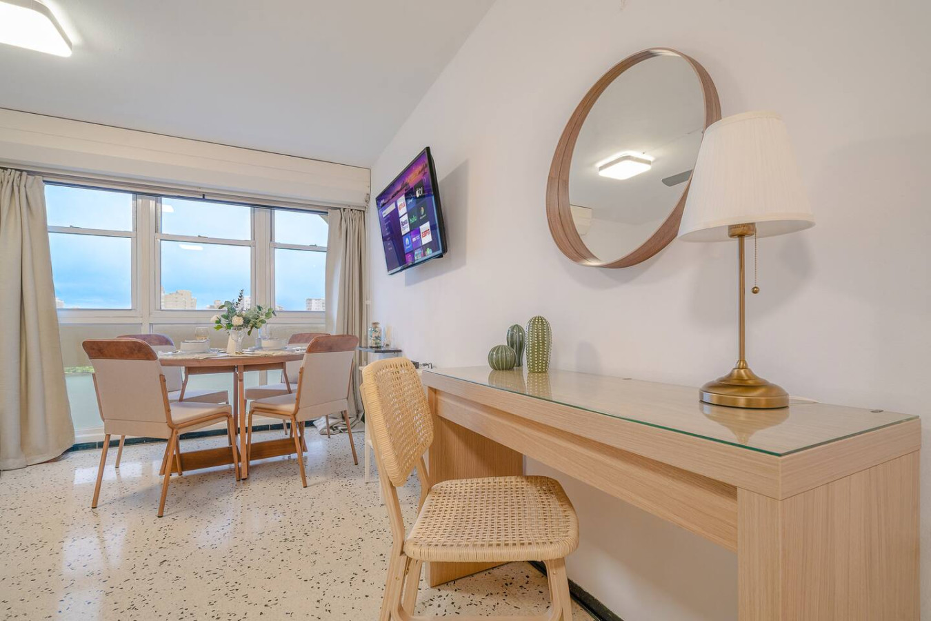 Dining room table with chairs and a TV in the background — Condado Penthouse, Condado