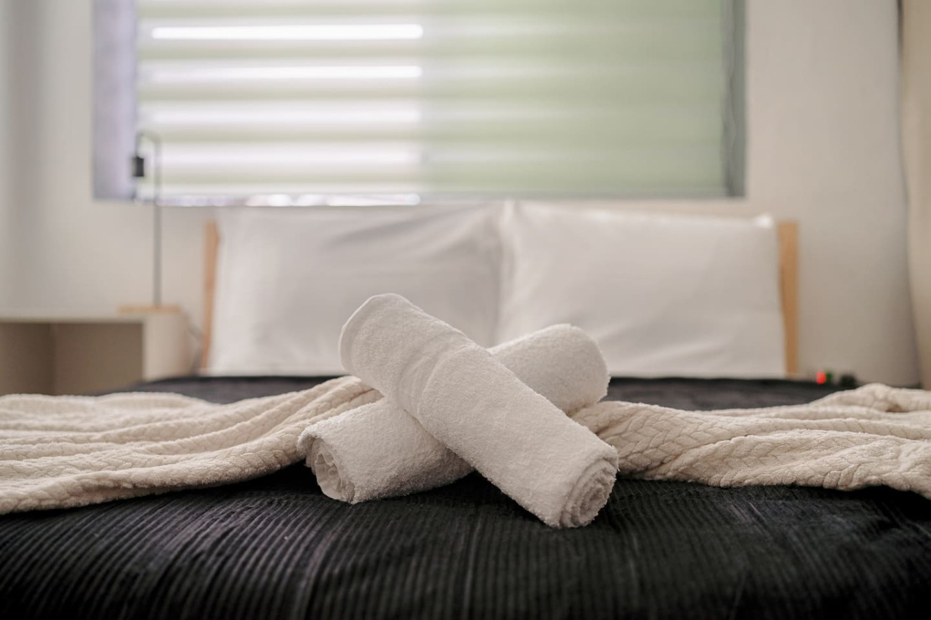 Two white towels on a bed — Puerto Lagoon Downtown, Santurce