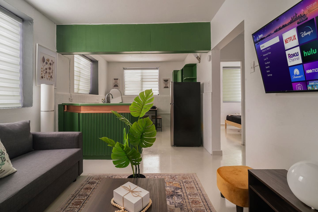 Living room with a green wall and a potted plant on a coffee table — Puerto Lagoon Downtown, Santurce