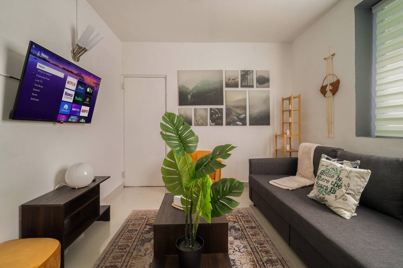 Living room with a couch, a potted plant, and a TV — Puerto Lagoon Downtown, Santurce