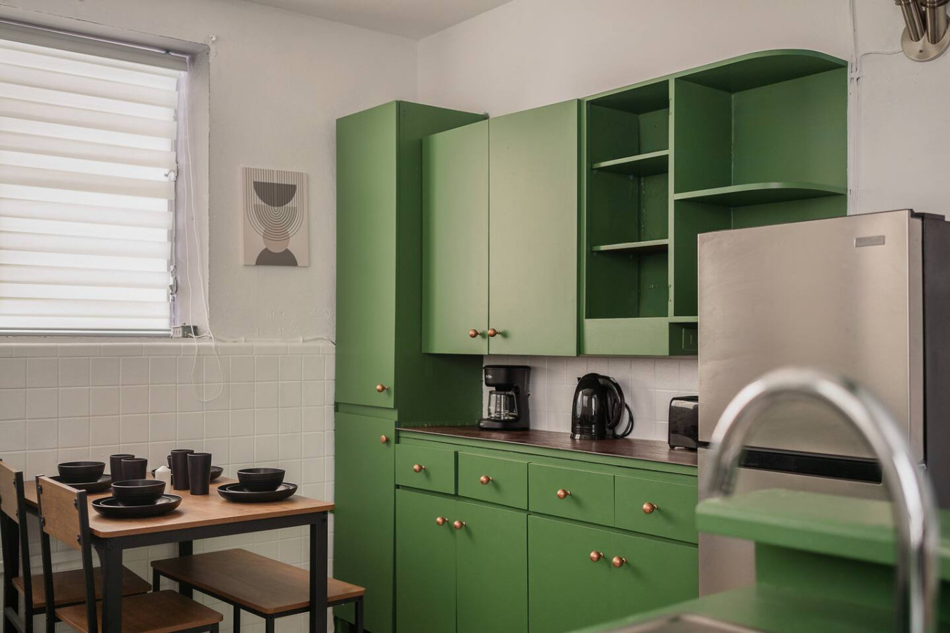 Kitchen with green cabinets and a small dining table — Puerto Lagoon Downtown, Santurce