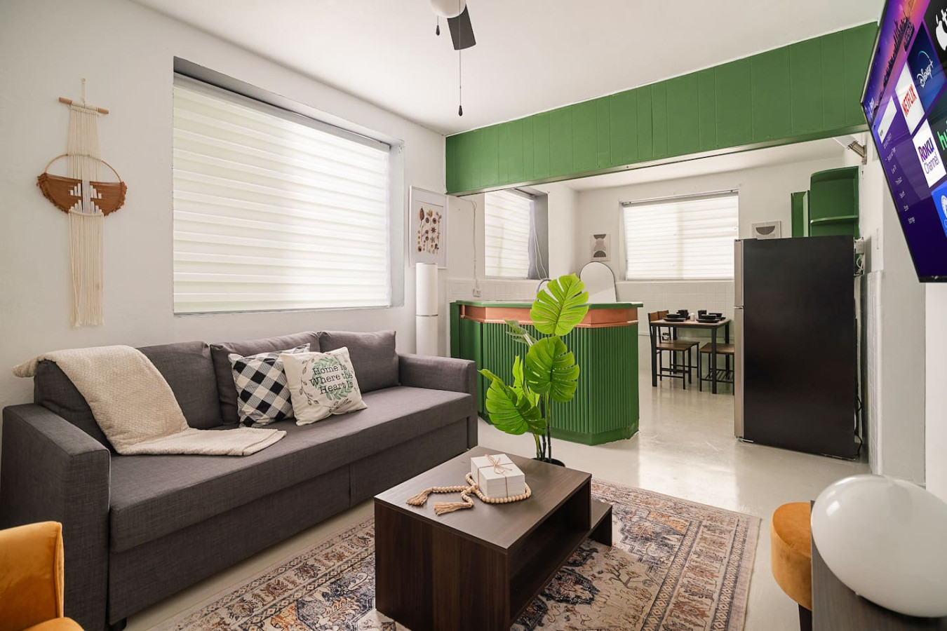 Living room with a couch, a potted plant, and a rug — Puerto Lagoon Downtown, Santurce