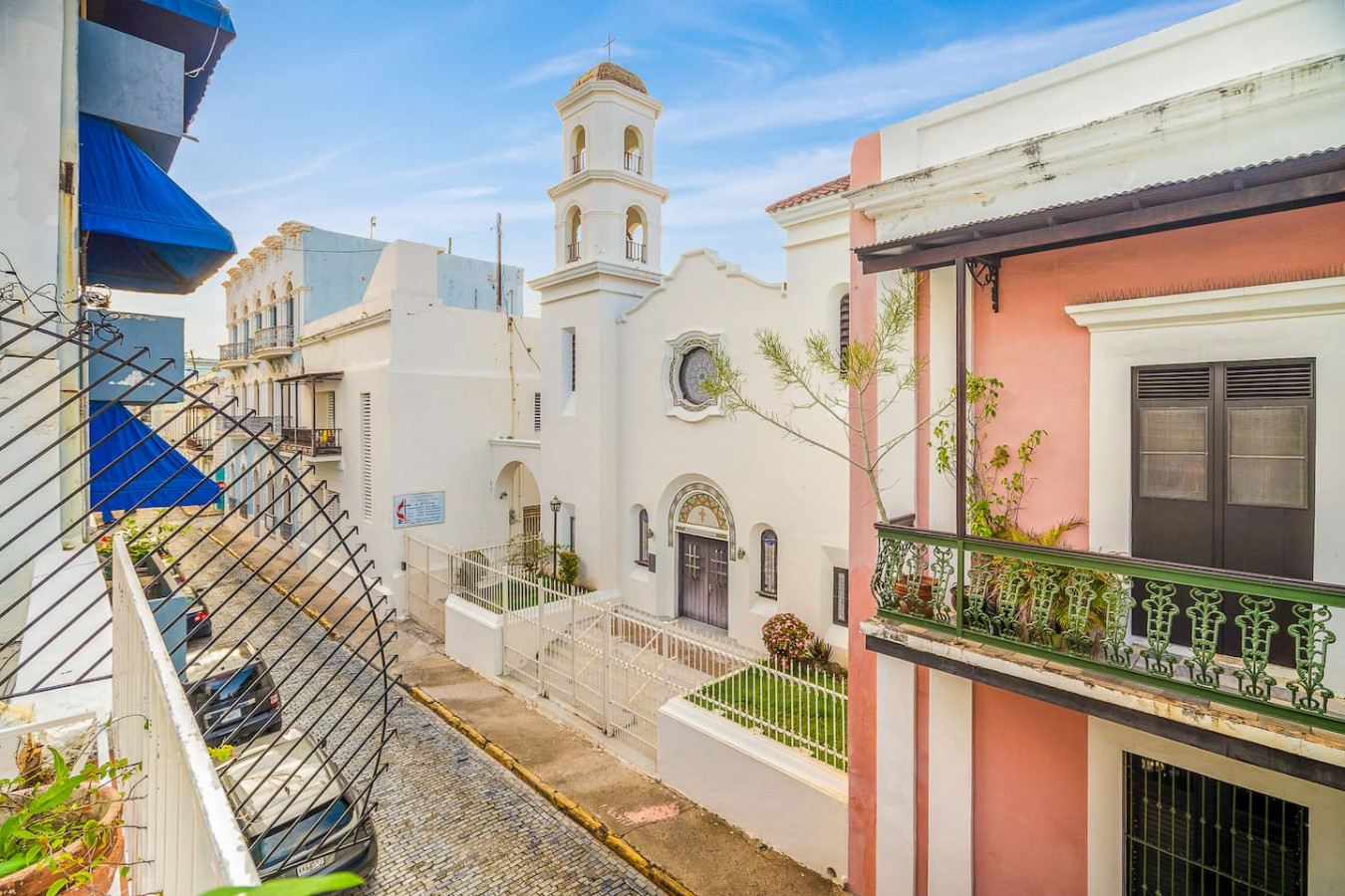 White church with a bell tower across the street — Villa Mansion - Fountain & Rooftop - Old San Juan