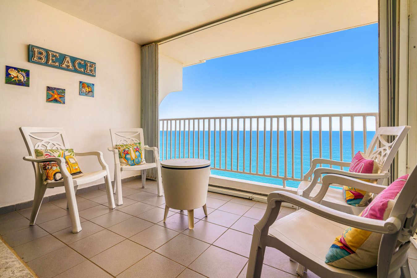White chair on a balcony overlooking the ocean — Captain’s Beachfront Luquillo Beach House, Luquillo