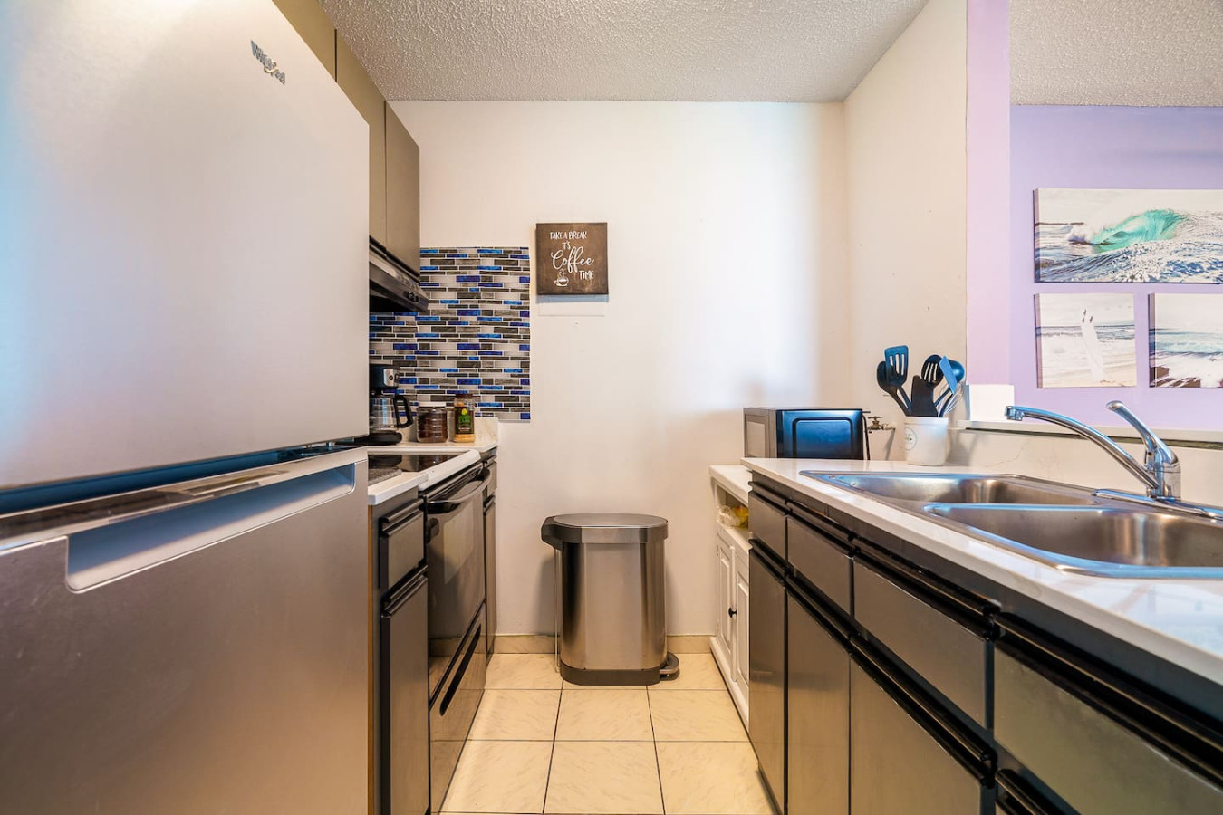 Galley kitchen with a stainless fridge and double sink — Captain’s Beachfront Luquillo Beach House