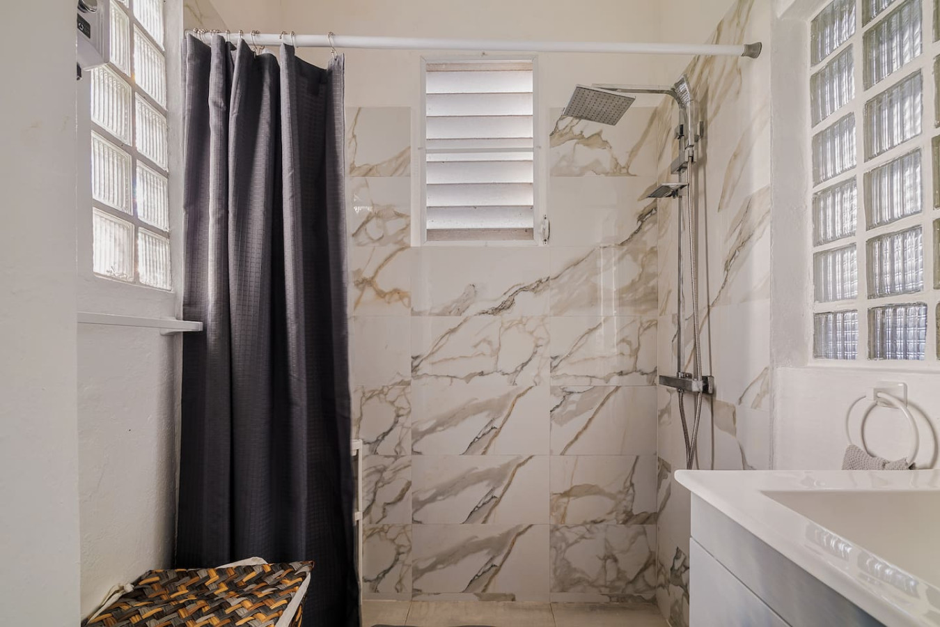 Bathroom shower with a rainfall head and marble-look tile — Tapia Mosaic Beachwalk - San Juan, Santurce