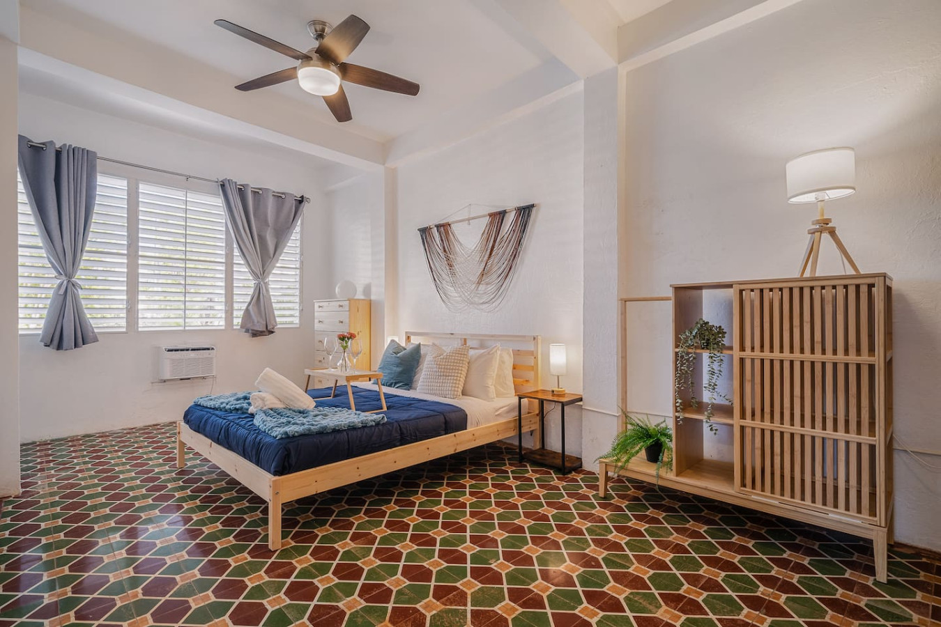 Bedroom with a blue bed and a fan — Tapia Mosaic Beachwalk - San Juan, Santurce