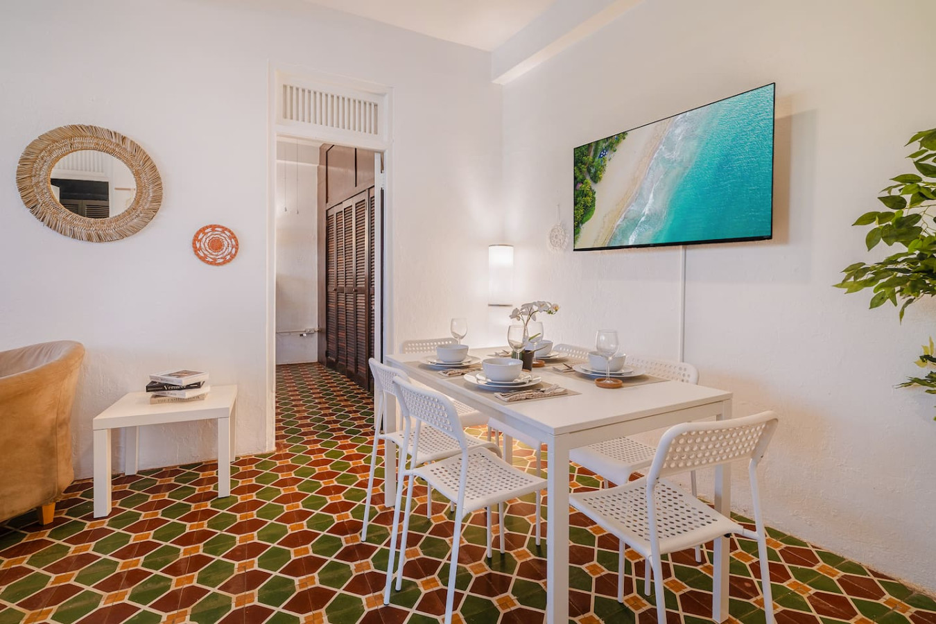 Dining room table with chairs and a TV in the background — Tapia Mosaic Beachwalk - San Juan, Santurce