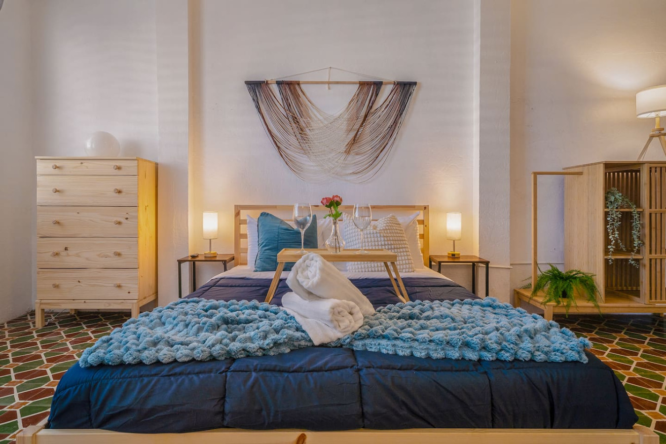 Bedroom with a blue bedspread and a white towel on it — Tapia Mosaic Beachwalk - San Juan, Santurce