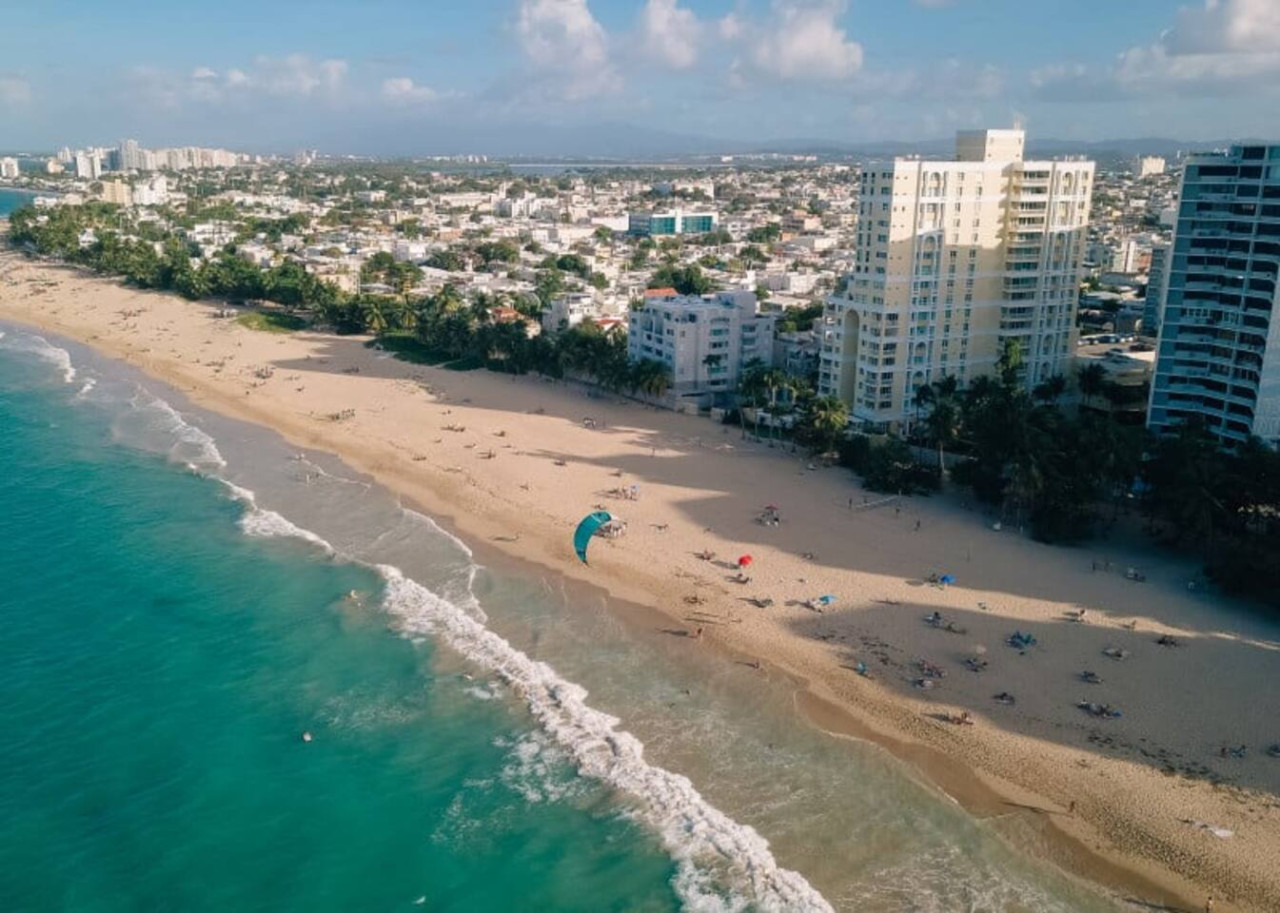 Beachfront property with a blue umbrella on the sandy beach — Tapia Mosaic Beachwalk - San Juan, Santurce